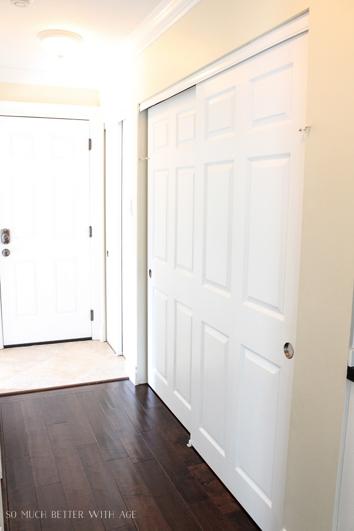 A hallway with wooden floors and white doors.


