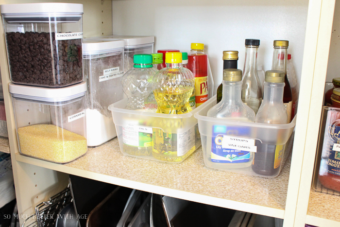 Oil, syrup and chocolate chips in containers in the pantry.