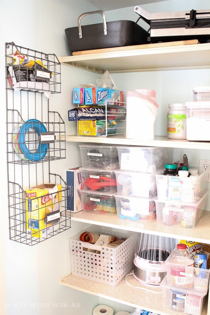 A wire rack on the wall with garbage bags in it, but racks on the shelves.