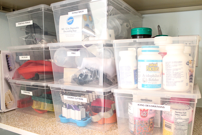 Clear bins housing vitamins, cake decorating supplies and cookie cutters.