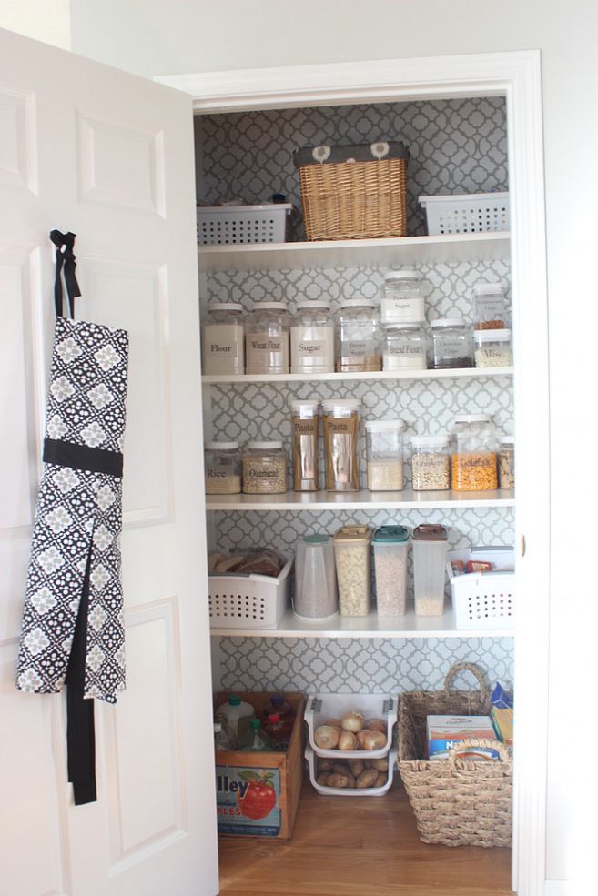 There is wallpaper on the wall in the pantry.