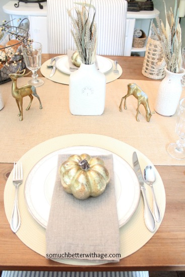 Table setting with gold deer and a gold pumpkin on the plates.