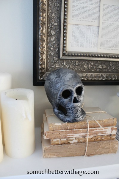 A skull on vintage books on the fireplace mantel.