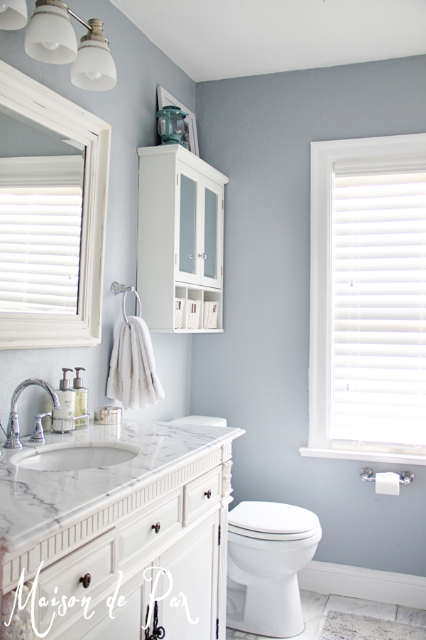 The master bathroom with marble counters and a soft grey blue on the walls.