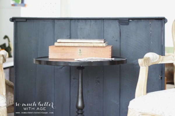 The back of the dresser painted with a small table behind it.