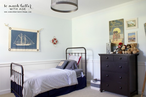 Child's bedroom with sailboat picture on wall.