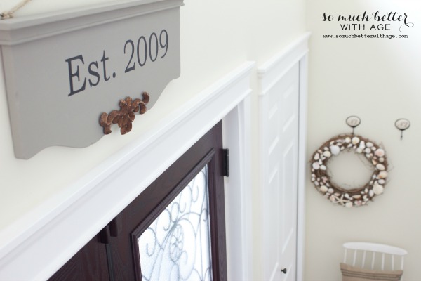 The sign, a door and a seashell wreath hanging up.