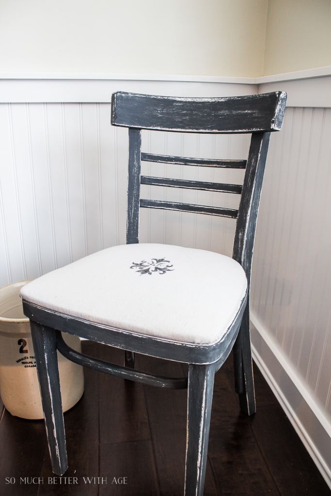 Distressed navy blue chair with stencil on seat. 