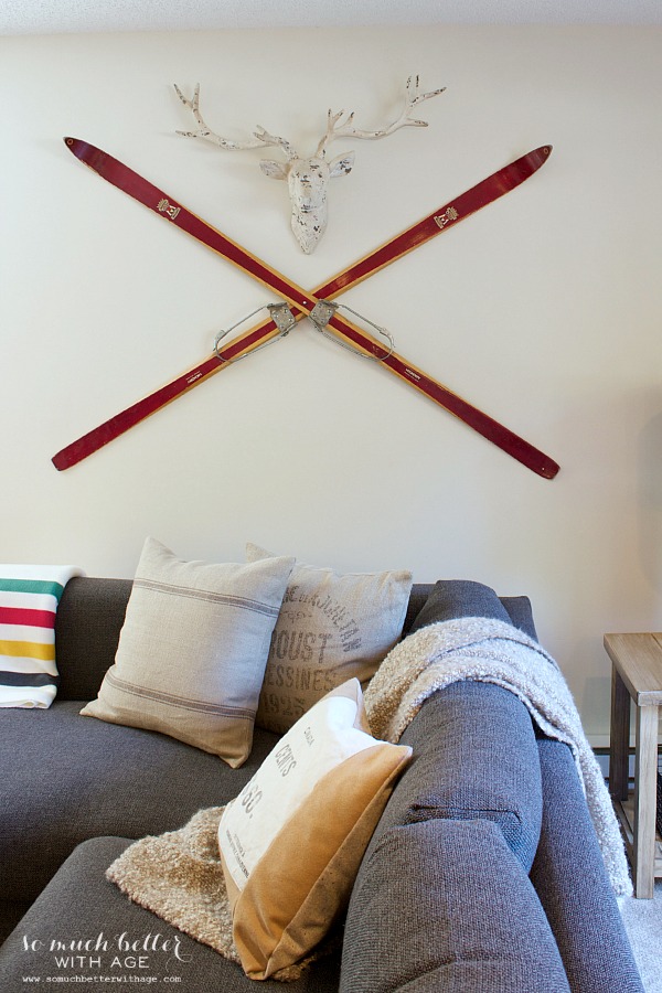 Old red skis on the wall with a deer head.