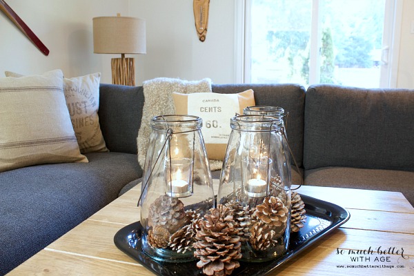 A wooden coffee table with the lanterns and pinecones.