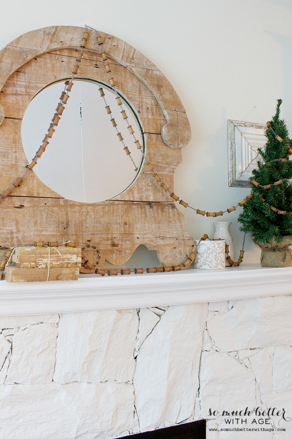 The spool garland is draped across the mirror on top of the mantle.