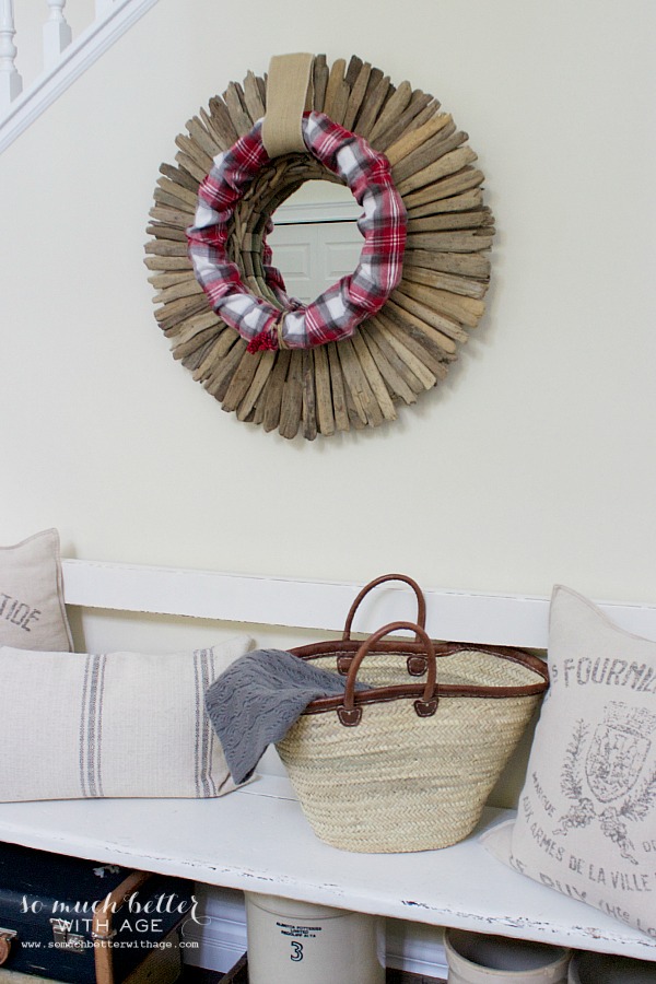 A driftwood mirror with the wreath hanging off it.