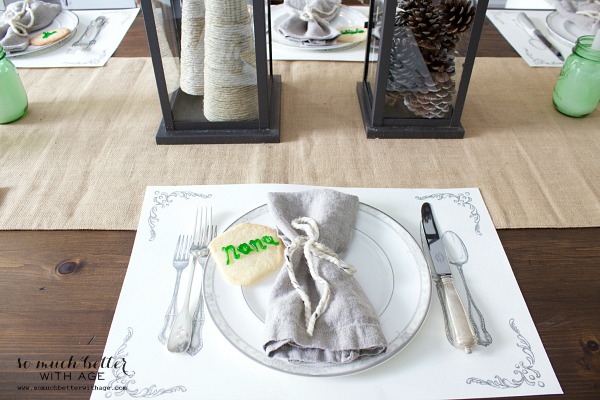 Table setting with sugar cookie monogramed with guest name in light green on plate.