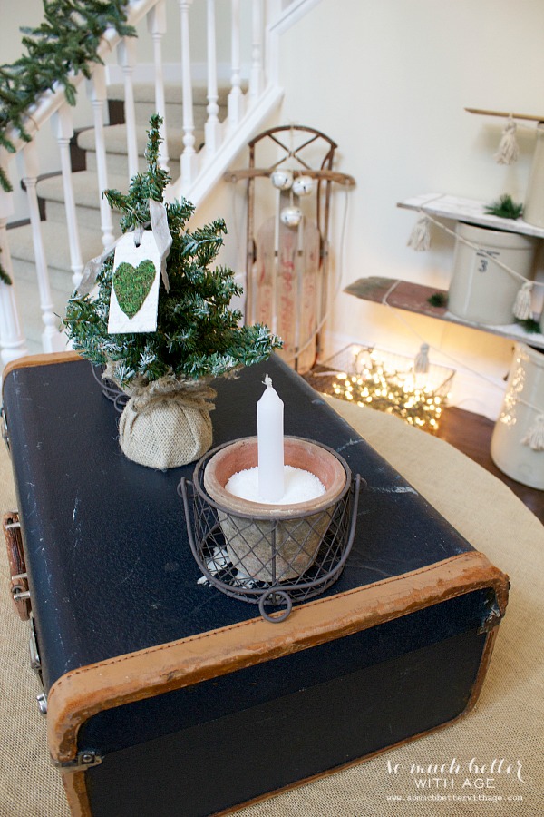 Candles are on top of a vintage suitcase.