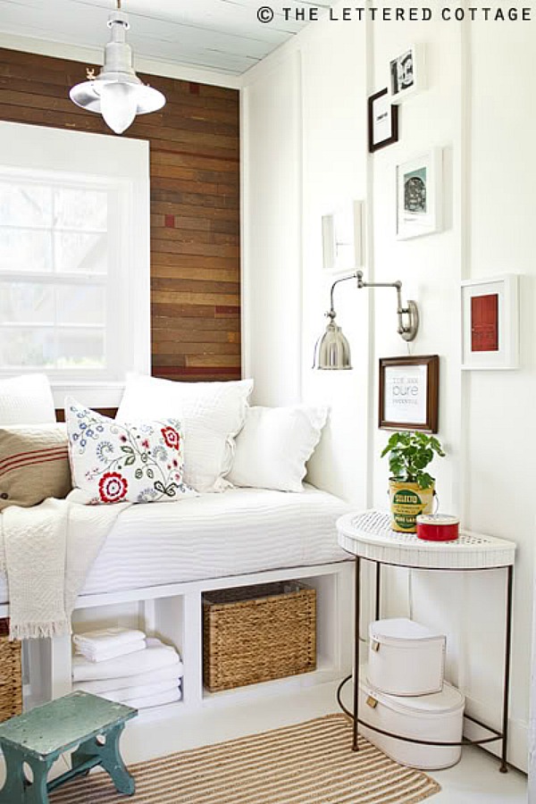 A daybed in front of a window in a white and wood room.
