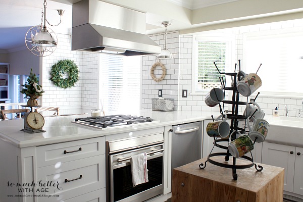 A white kitchen with a wooden butcher block in the middle.