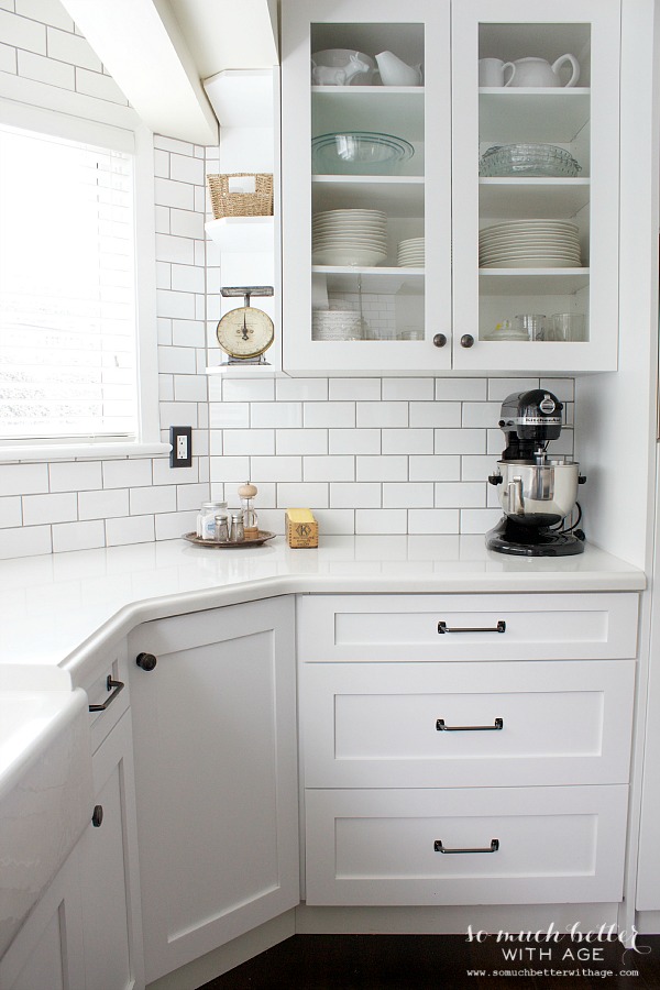 Industrial Vintage French kitchen with white backsplash and cabinets.