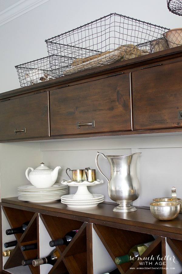 Brown cabinet with wire baskets on top.