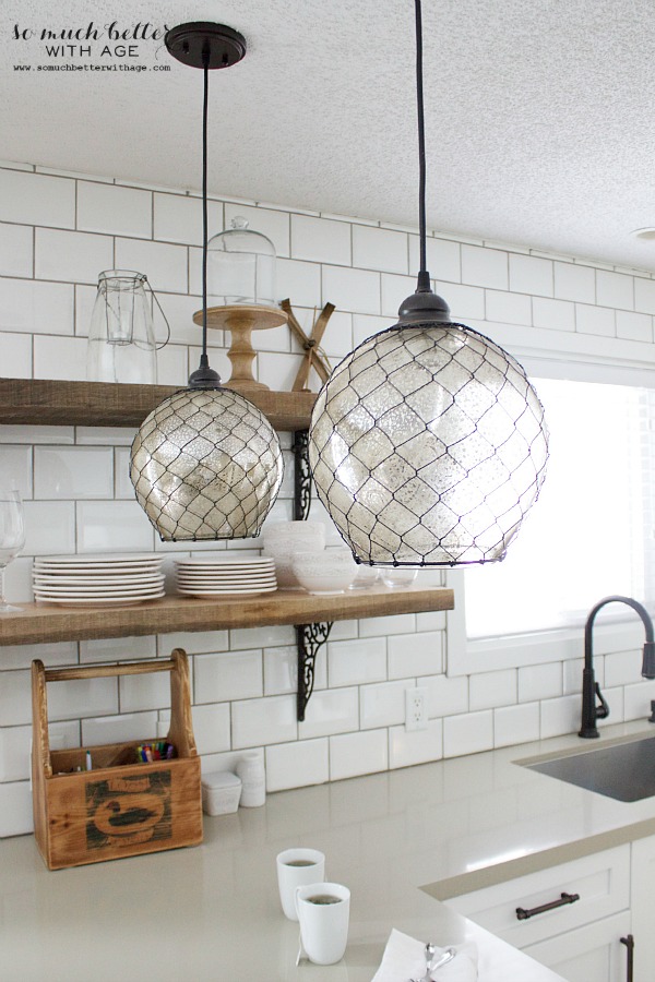 Rustic industrial kitchen subway tile in the kitchen by the open wooden shelves.