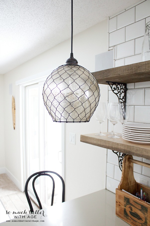 The white industrial kitchen with wooden shelves a wooden box on the counter.