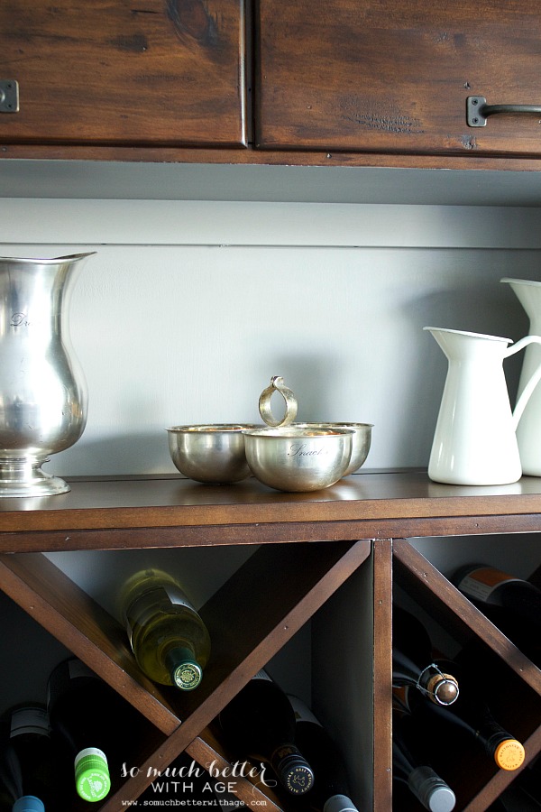 Silver bowls on cabinet shelf.