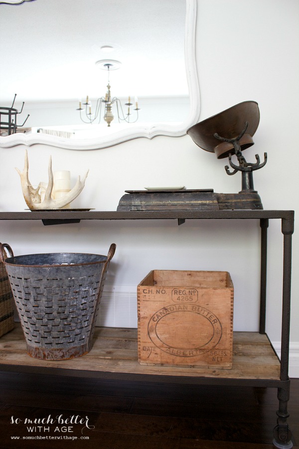 A vintage rustic metal bucket and a wooden box on the shelf underneath the side table.