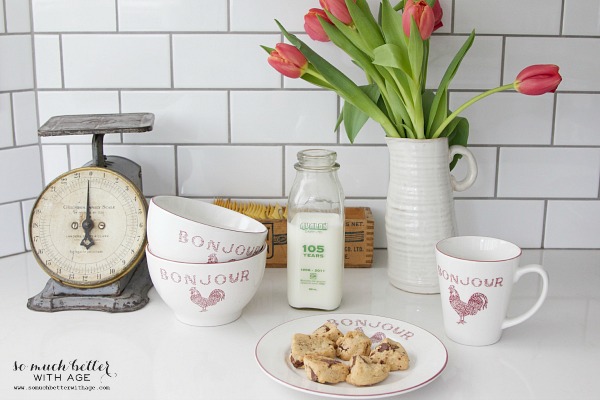 A vase filled with pretty tulips is on the counter.