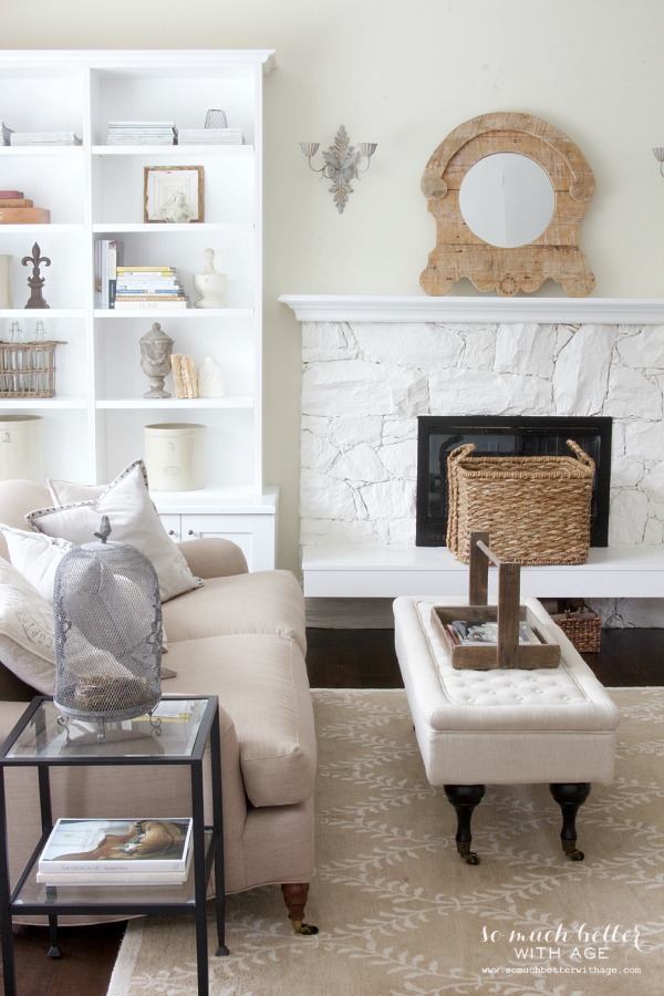 A neutral living room with a white ottoman and a two loveseat couch.