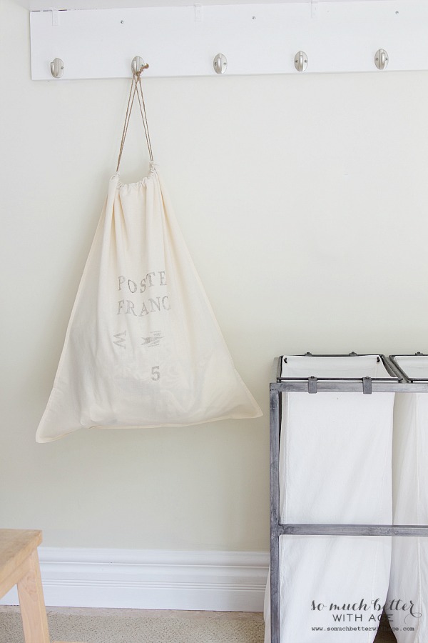 White laundry bag hanging on a hook.