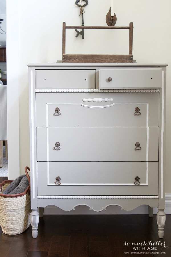 Dresser with one drawer open painted a subtle white.