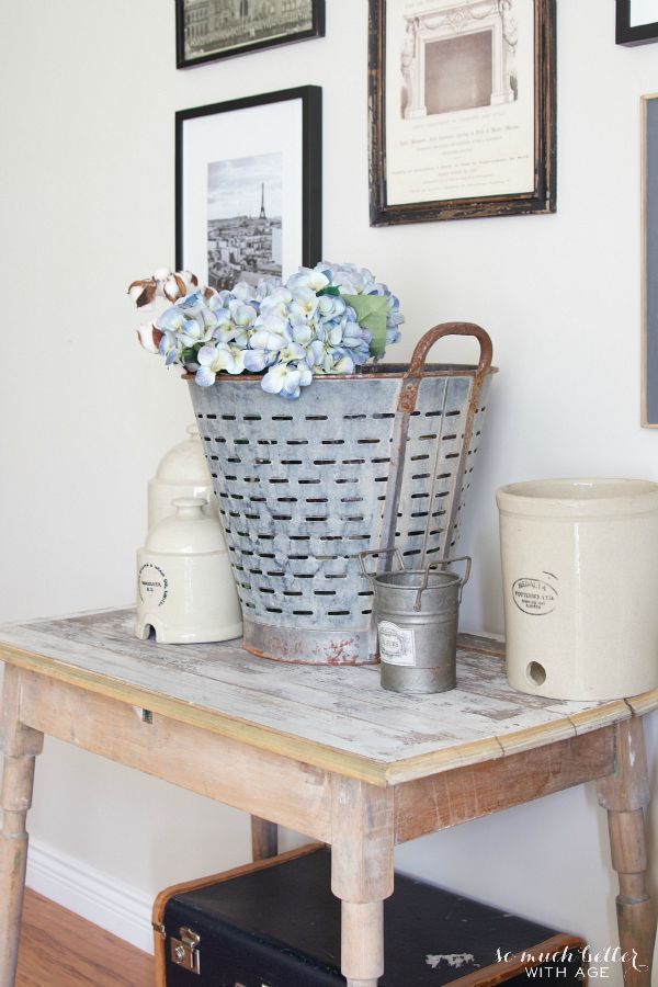 Wooden table with crocks and flowers on it.