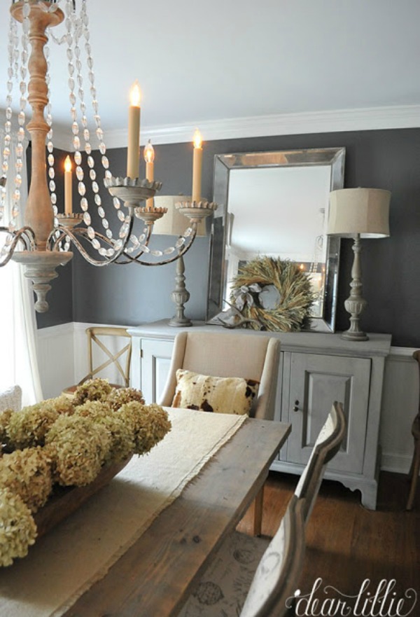 Gray neutral dining room with wooden chandelier above wooden table.