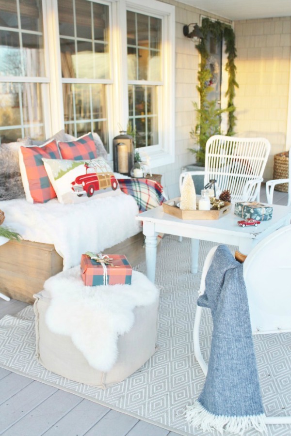Outdoor seating area with Christmas pillows and presents.