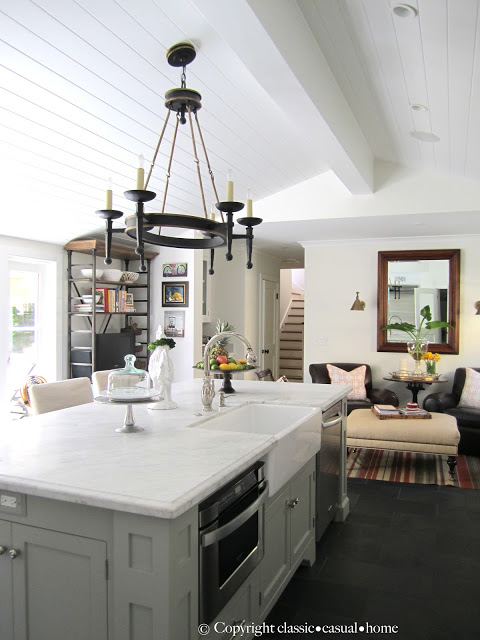 White island counter with a gray base and large light fixture above the island.