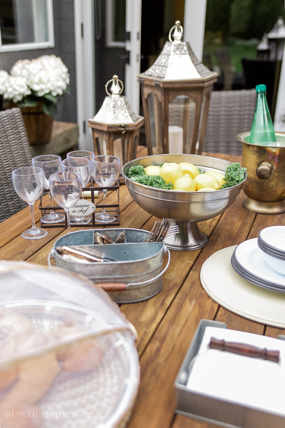 A wooden outdoor table being set with vintage details.