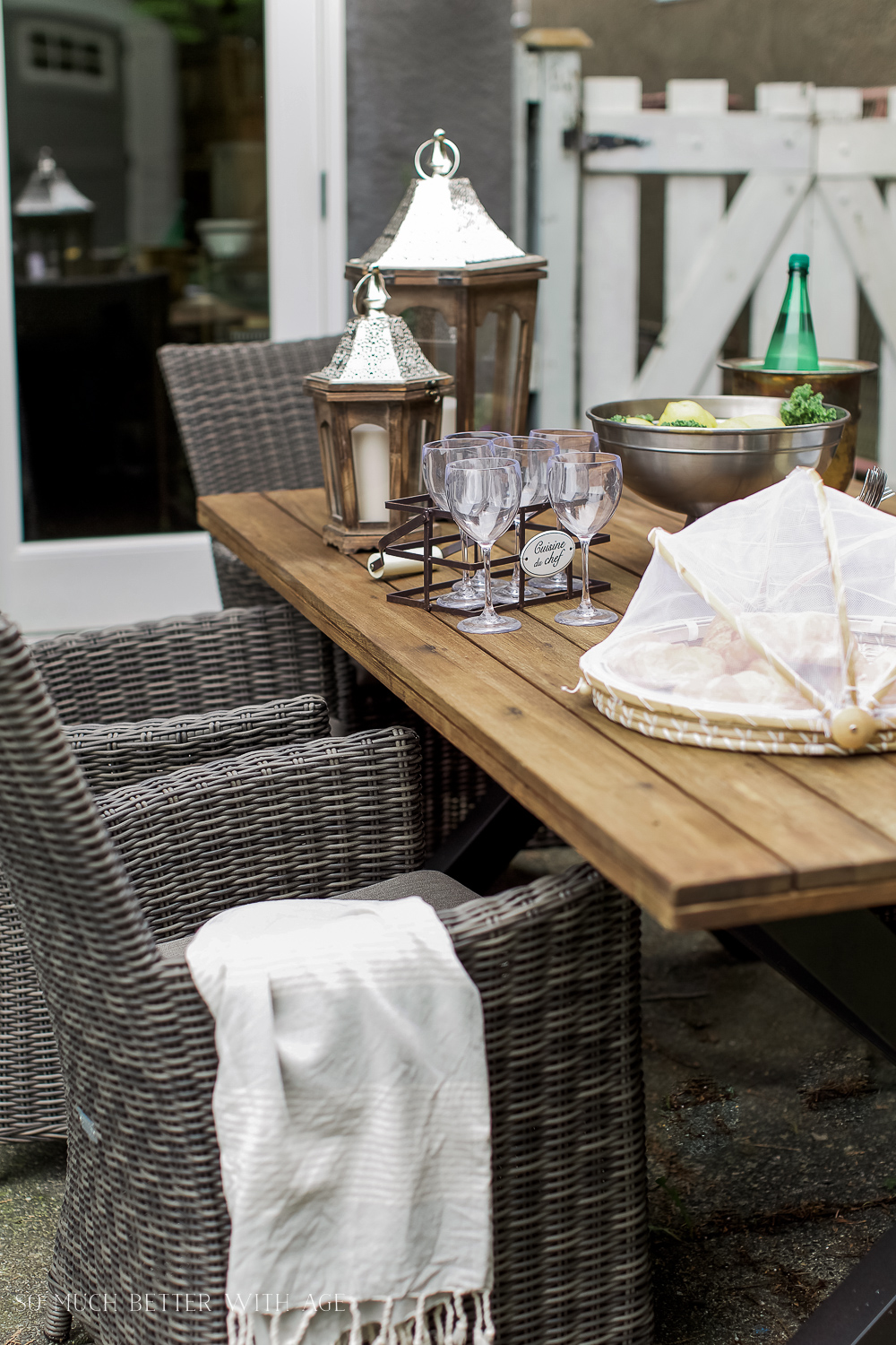 Wine glasses, candle holders, and a silver food tray on the table.