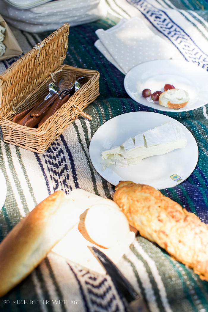 Bread, brie and grapes on the blanket.