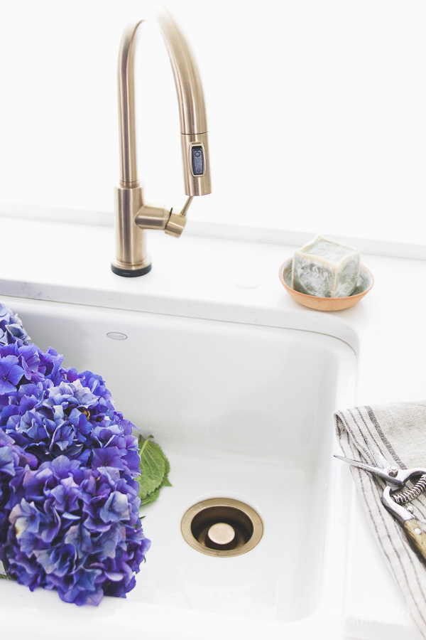 There is a little bar of soap in a dish on the sink in the kitchen.