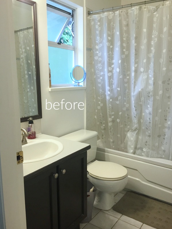 The bathroom vanity with a white counter and dark brown cabinet.