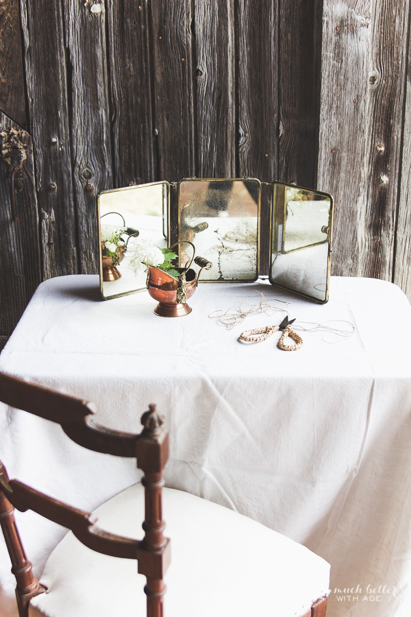 There is a table with old mirrors on it beside some scissors.