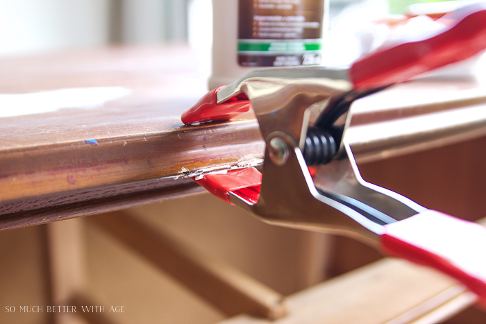 Clamp with wood glue on top of furniture piece. 