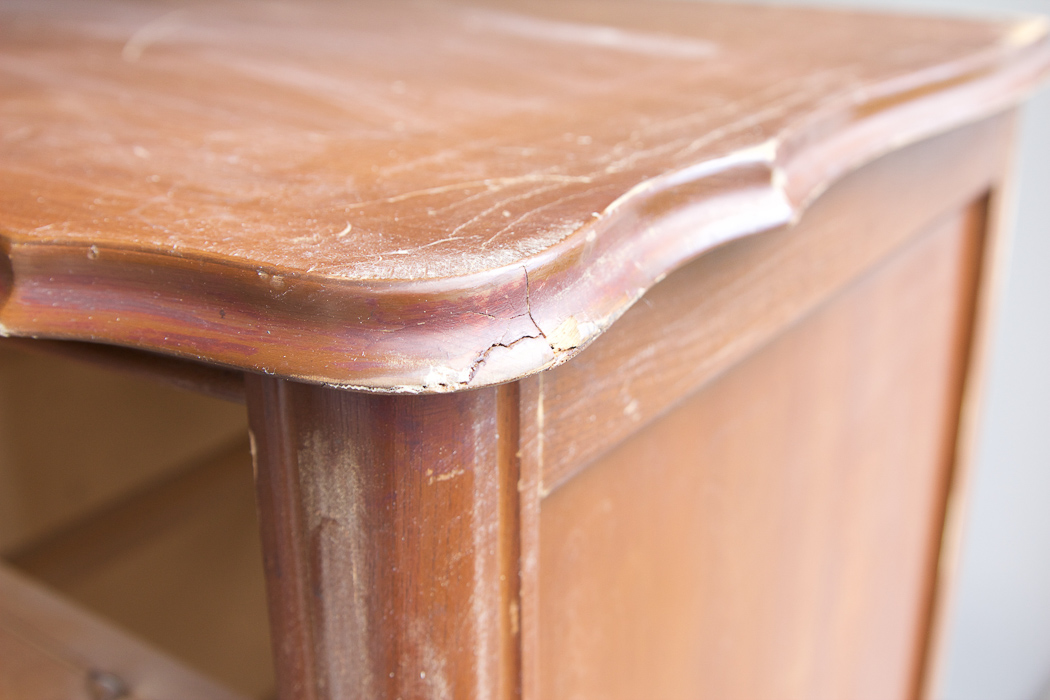 Close-up of crack on edge of wooden dresser. 