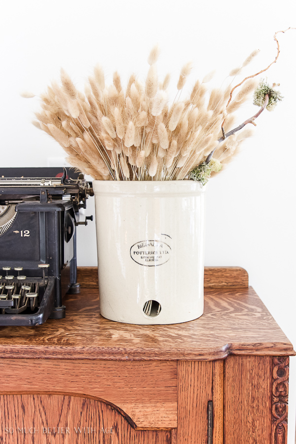 The wheat filled crock beside a vintage typewriter.