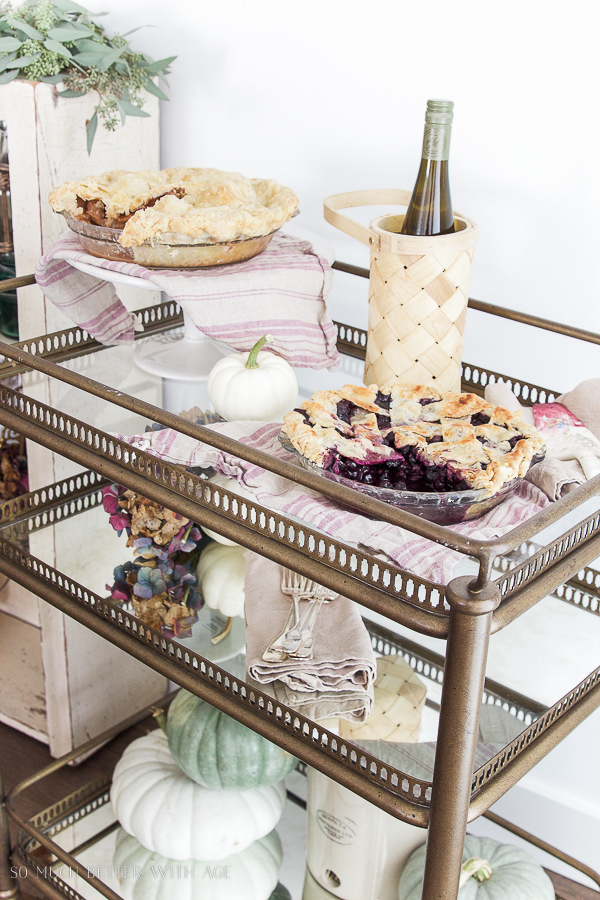 The pie on a bar cart next to a bottle of wine chilling.