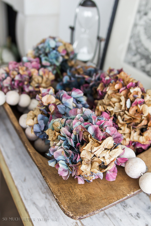 Purple and blue hydrangeas in a wooden bowl.