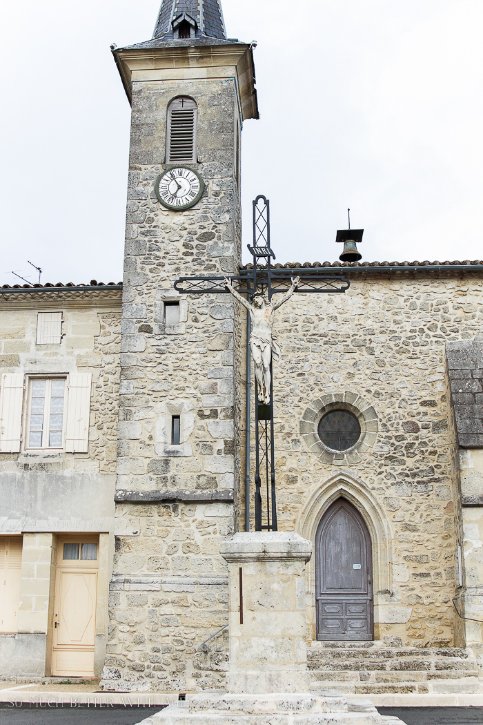 A French countryside old church with a clock in the steeple.