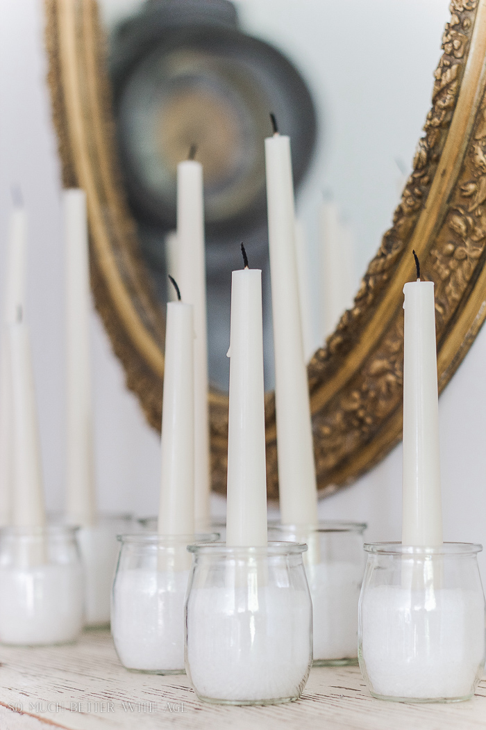  Jars with epsom salts and candles in them in front of a gold mirror. 