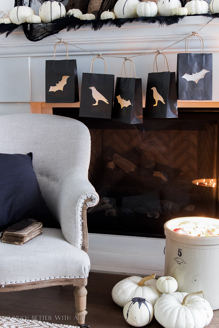  A crock filled with floating candles beside the fireplace.   A neutral French armchair beside it.