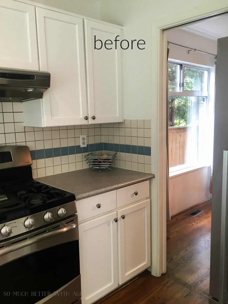 Kitchen before photo with white cabinets and blue and white tile backsplash.