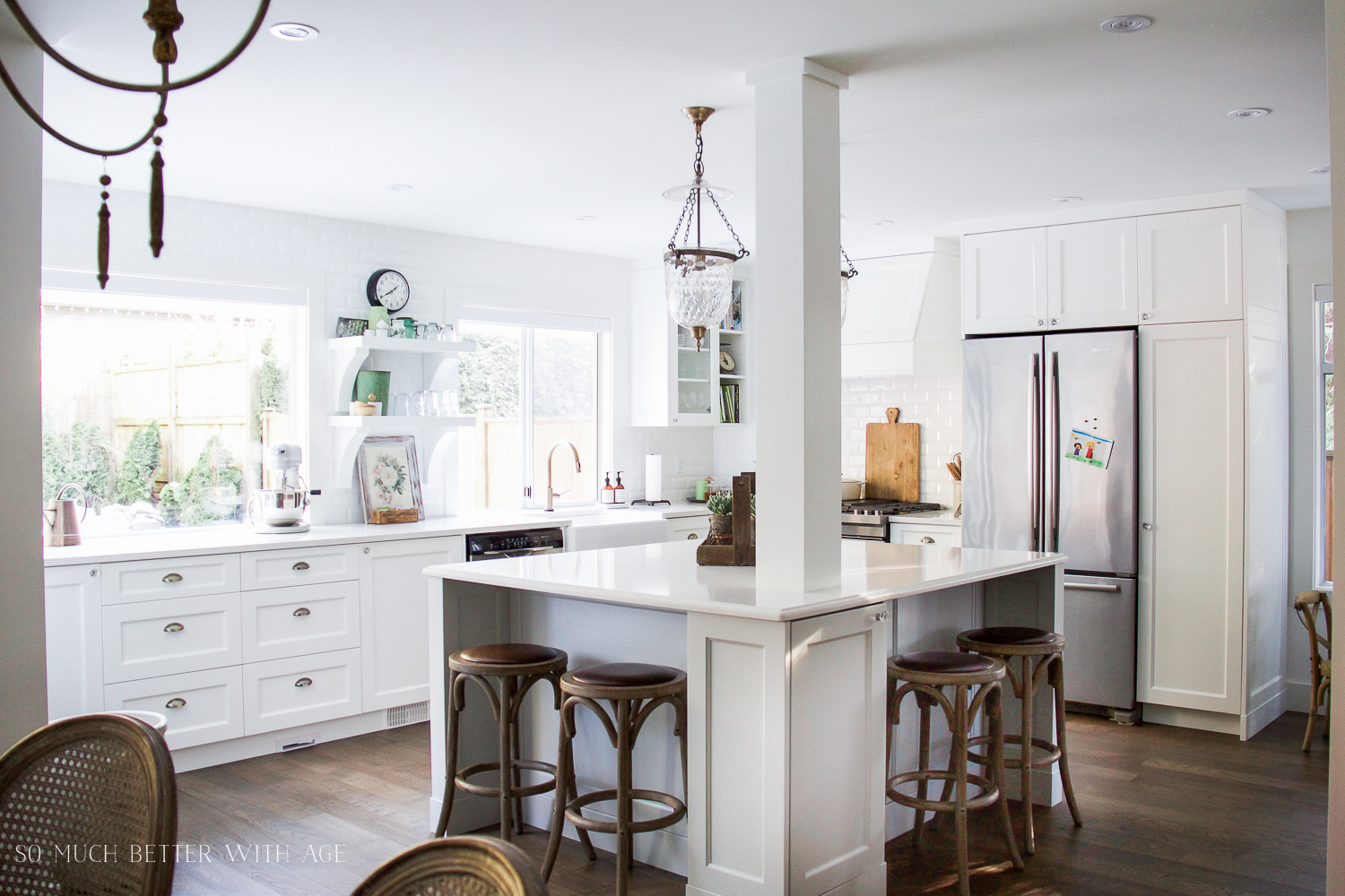 A large white kitchen island with brown stools.